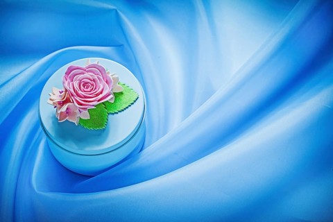 Round gift box on blue fabric background holidays concept