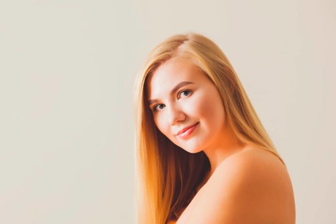 Portrait of a beautiful blonde woman with bare shoulders and back wearing natural make-up against