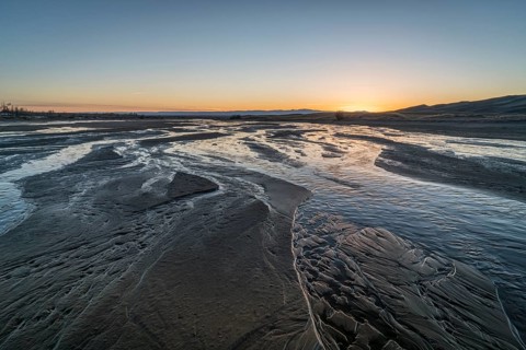 Sunset over shallow Medano Creek disappearing in sand - Great Sand Dunes National Park, Colorado