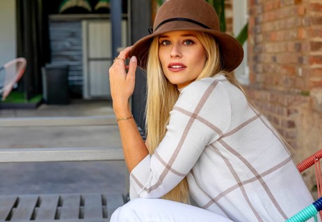 Blonde beauty exudes joy in stylish fall attire, radiating high spirits on a stunning autumn day