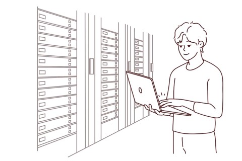 Male engineer with laptop standing near server room with computers. Man IT specialist working in