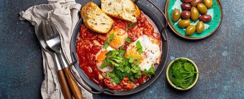 Middle Eastern and Maghrebi healthy dish Shakshouka made of eggs and tomato sauce served in pan