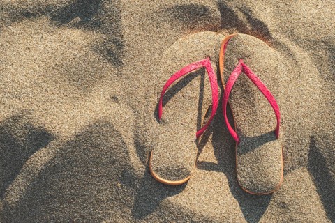 Pink sandals on the beach in the sand