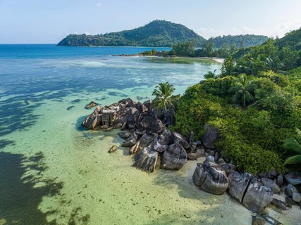 Rocks and palm trees surrounded by clear water on a tropical beach on an island, SEYCHELLEN, Port