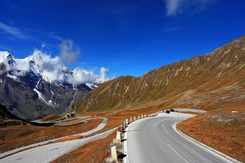 Austrian Alps. Tape highway winds between hillsides yellowed. Excursion to the picturesque