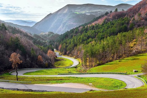 Winding mountain road serpentine after the rain. Wet asphalt. Cloudy winter day. Italy. Magnificent