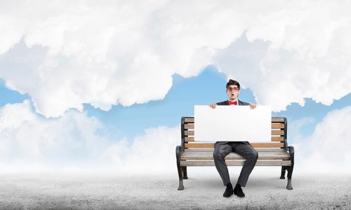 Young businessman holds a large white banner. sits on the bench