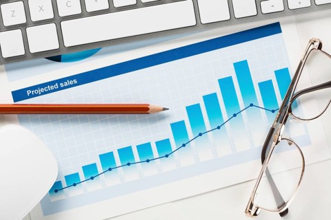 Business workplace with keyboard mouse and papers with graphs and diagrams
