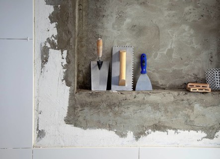 Construction stainless steel trowel tools and spatula on cement mortar wall