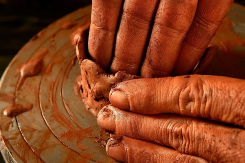 Pottery craftmanship red clay potter hands work finger closeup