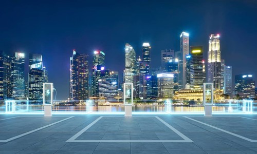 Empty parking lot with ev chargers glowing against the backdrop of singapore's illuminated skyline