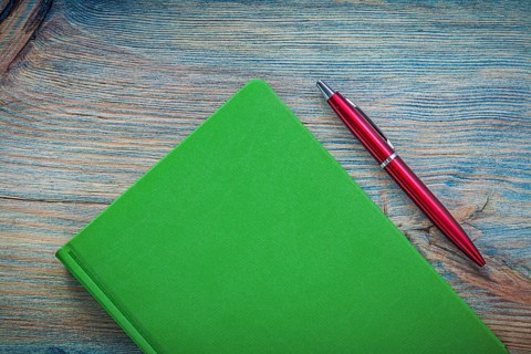 Notepad ball-point pen on wooden board top view education concept