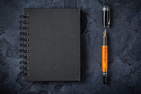 Black Notepad And Fountain Pen On Black Background