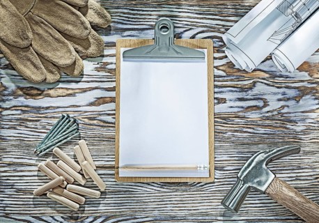 Protective gloves clipboard claw hammer blueprints nails wooden dowels