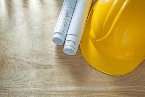 Building helmet blueprints on wooden board