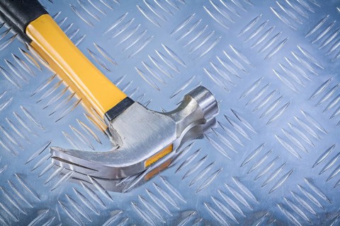 Claw hammer on corrugated metal background construction concept