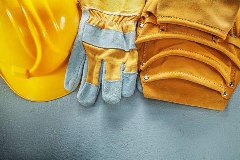 Tool belt protective gloves cap on concrete background