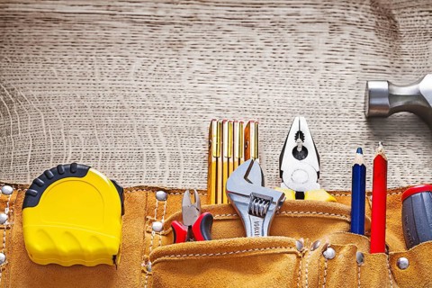 Leather tool belt with construction equipment on wooden board
