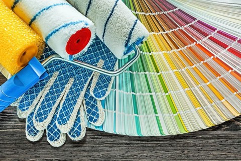 Paint rollers safety gloves color palette on wooden board