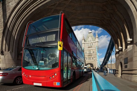 The famous Tower Bridge in London, UK. Double-decker bus passes under the arch of the tower. Sunny