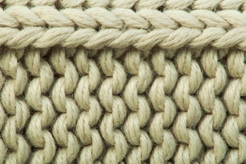 Old knit sweater background. Beige color. Studio shot