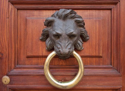Antique door knocker in the form of a lion's head on old wooden door, Rome, Italy, Europe