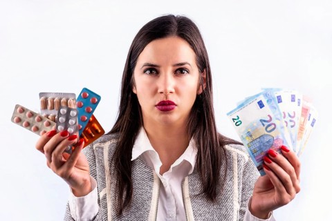 Different colorful pills and capsules in blisters and euro banknotes in the hands of angry young