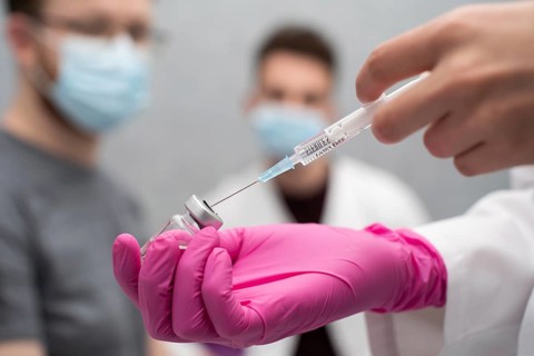 In a practical lesson, a young nurse shows medical trainees how to correctly draw a medicine from a