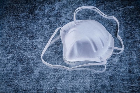Safety dust mask on metallic background construction concept