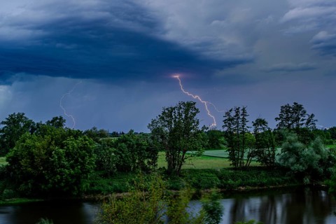 Bright flashes of lightning have illuminated the dark sky over a river, Bogen, Lower Bavaria