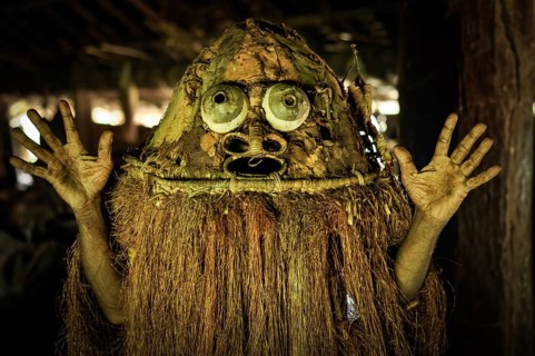 Photo of native man in costume with raised hands in Palembe, Sepik river in Papua New Guinea. In