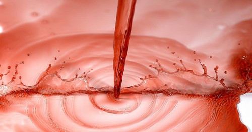 Red Wine being poured against White Background