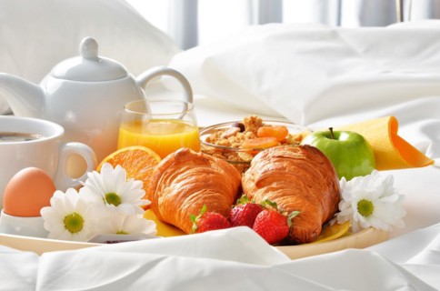 Breakfast tray in bed in hotel room