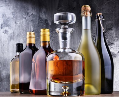 Composition with carafe and bottles of assorted alcoholic beverages