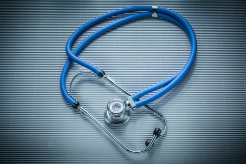 Medical stethoscope on striped background, view from above