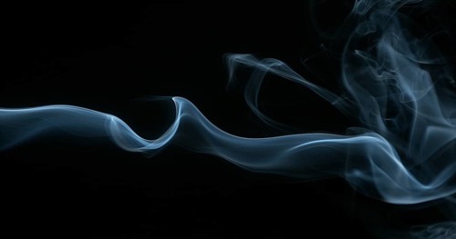 Smoke of Cigarette rising against Black Background