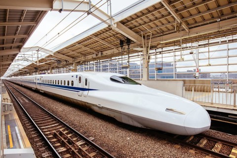 A Shinkansen high-speed bullet train pulling into a train station in Japan