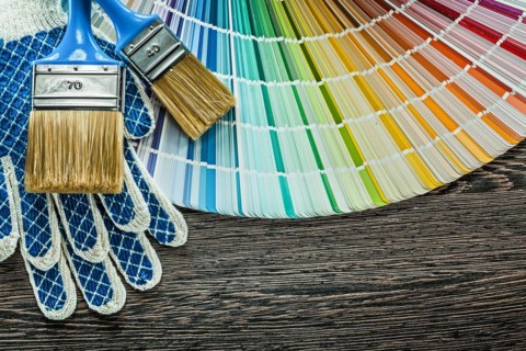 Pair of safety gloves paint brushes color sampler on wooden board