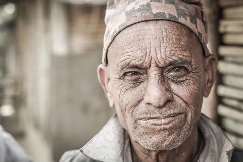 Damak, Nepal, circa April 2012: Older man with wrinkled face wears cap on his head at Nepali