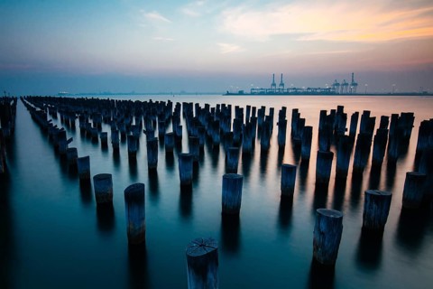 The historic Princes Pier featuring many disused pylons on a hot summer's day in Port Melbourme,