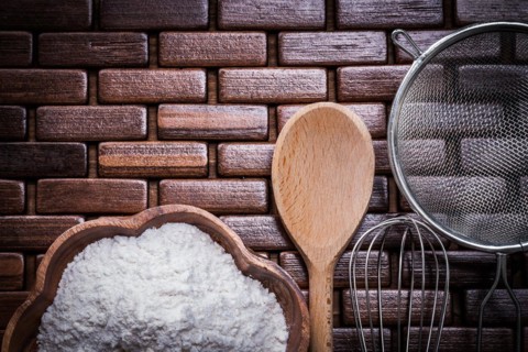 Wood spoon bowl flower sieve and egg-whisk on wooden matting