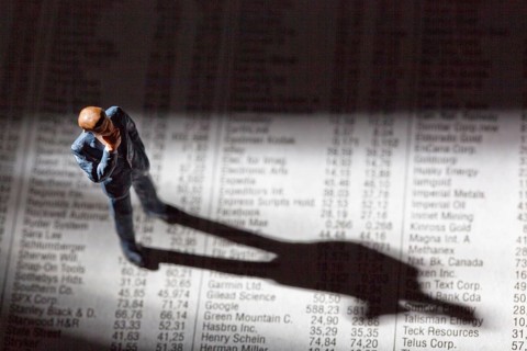 A small figure and the prices of shares in a newspaper. Earning money on the stock market. Profits