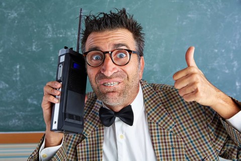 Nerd silly private investigator with retro walkie talkie on teacher balckboard