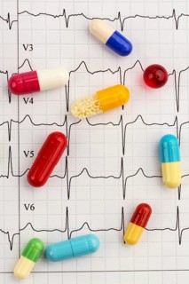 Several tablets lie on an ECG. Symbolic photo for diseases of the heart and circulation Austria