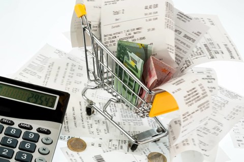 Shopping trolleys, banknotes and receipts, symbolising purchasing power, consumption and inflation