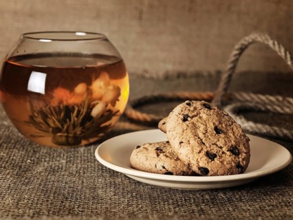 Cookies in front of blossom tea over the burlap background