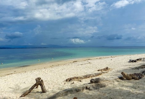A fine, beige sandy beach on Borneo Malaysia . Intense clouds over a turquoise-coloured sea