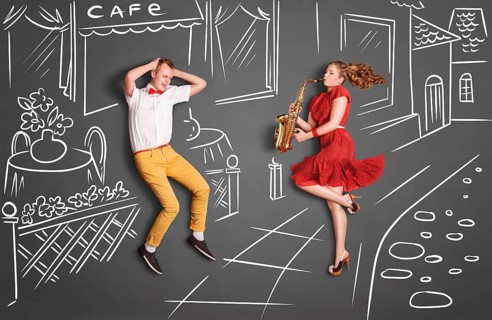 Love story concept of a romantic couple against chalk drawings background. Woman playing the