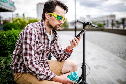 Caucasian man uses modern technologies Internet and cellular communication on smartphone while