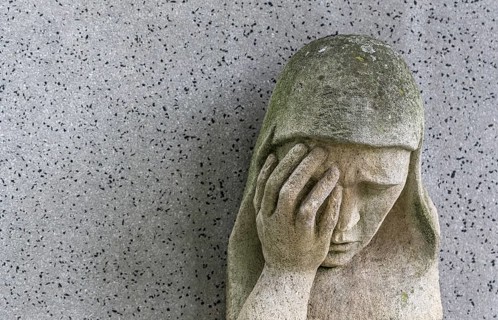 A sad Madonna in the Barbarafriedhof cemetery in Linz, Austria, Europe
